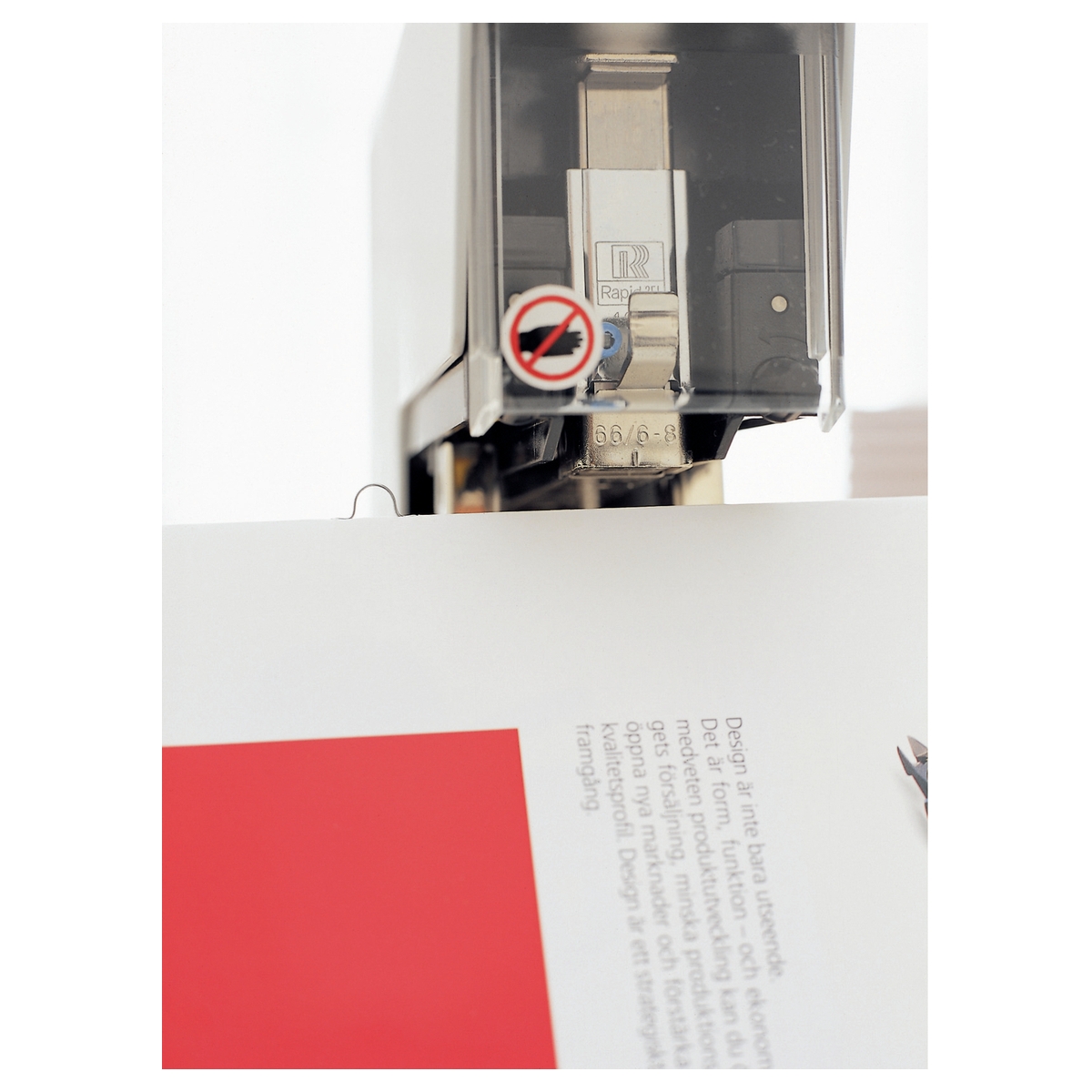 Tête d'agrafage de l'agrafeuse électrique RAPID Classic 106E au-dessus d'une brochure.