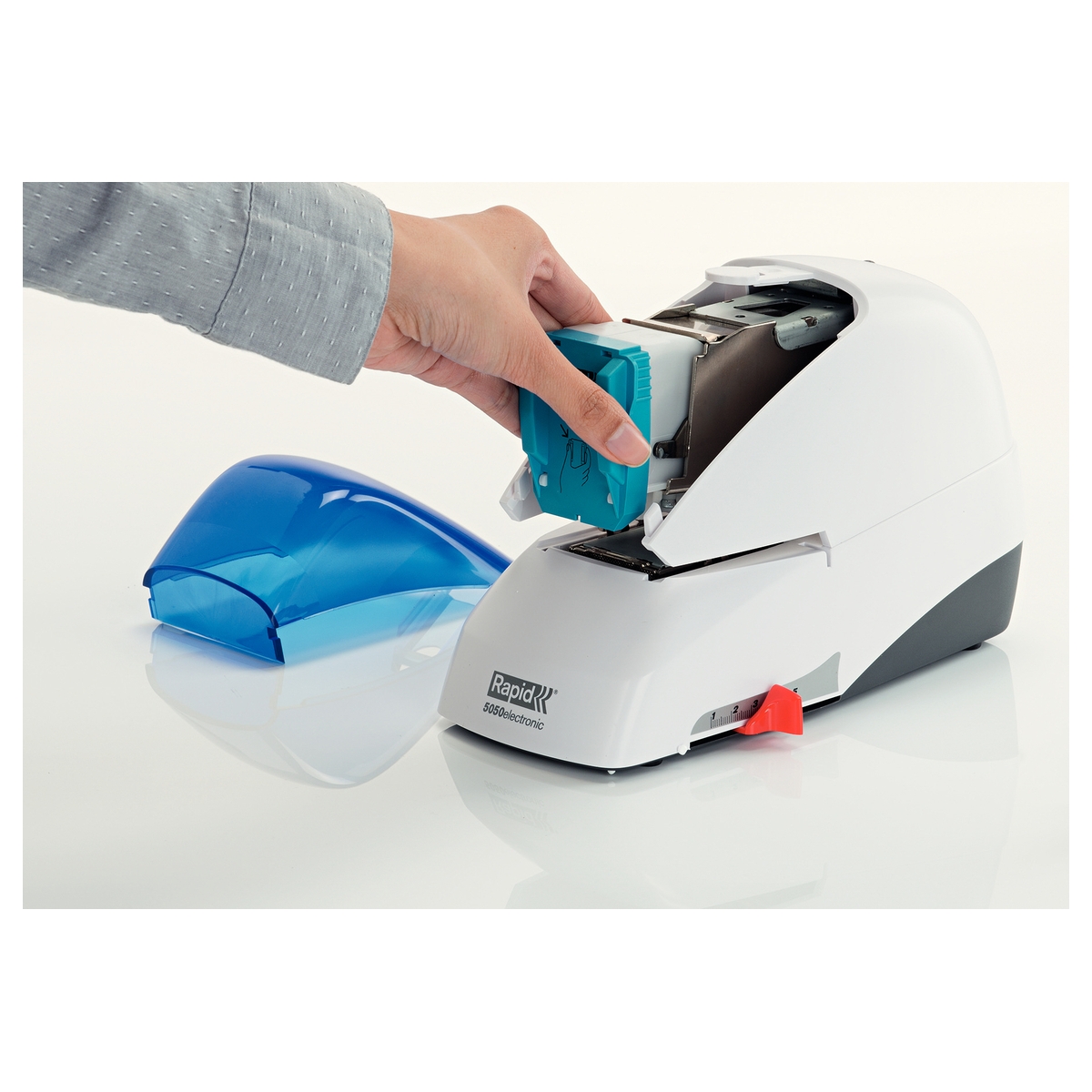 Insertion de la cassette de 5 000 agrafes par l'avant de l'agrafeuse électrique RAPID Supreme 5050E, coloris blanc et bleu.